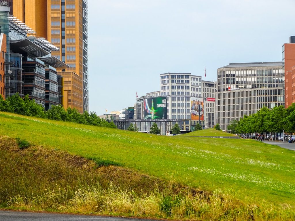 Landscape perkantoran modern dengan bangunan tinggi dan taman hijau.