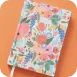 Notebook dengan sampul motif bunga di atas latar oranye
