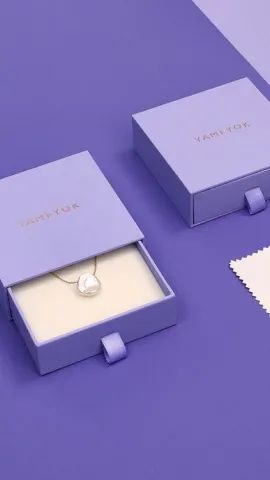 Kotak perhiasan ungu matte dengan kalung liontin yang terlihat